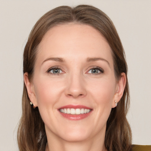 Joyful white adult female with long  brown hair and grey eyes