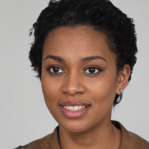 Joyful black young-adult female with short  black hair and brown eyes