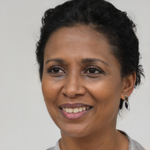 Joyful black adult female with medium  brown hair and brown eyes