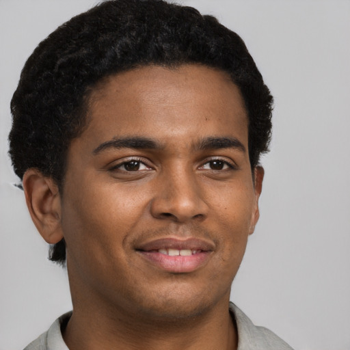 Joyful black young-adult male with short  brown hair and brown eyes
