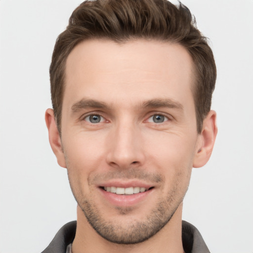 Joyful white young-adult male with short  brown hair and grey eyes