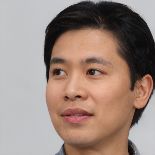 Joyful asian young-adult male with short  black hair and brown eyes