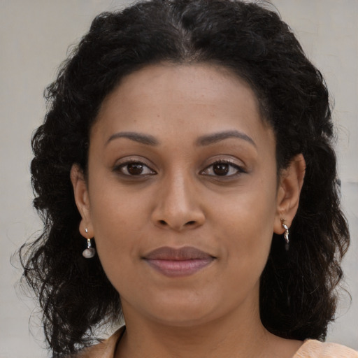 Joyful black young-adult female with long  brown hair and brown eyes