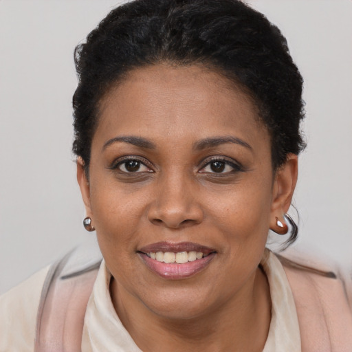 Joyful black young-adult female with short  black hair and brown eyes