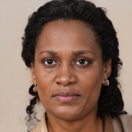 Joyful black adult female with long  black hair and brown eyes