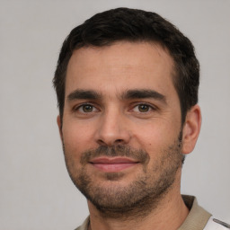 Joyful white young-adult male with short  black hair and brown eyes