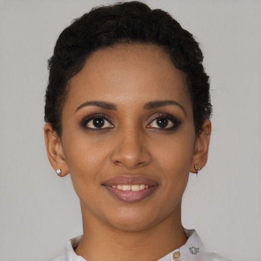 Joyful black young-adult female with short  brown hair and brown eyes