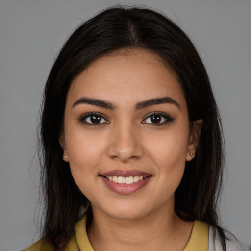 Joyful latino young-adult female with long  brown hair and brown eyes