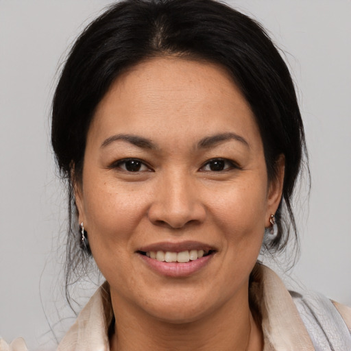 Joyful latino adult female with medium  brown hair and brown eyes