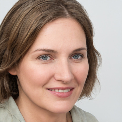 Joyful white young-adult female with medium  brown hair and blue eyes