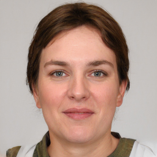 Joyful white young-adult female with short  brown hair and green eyes