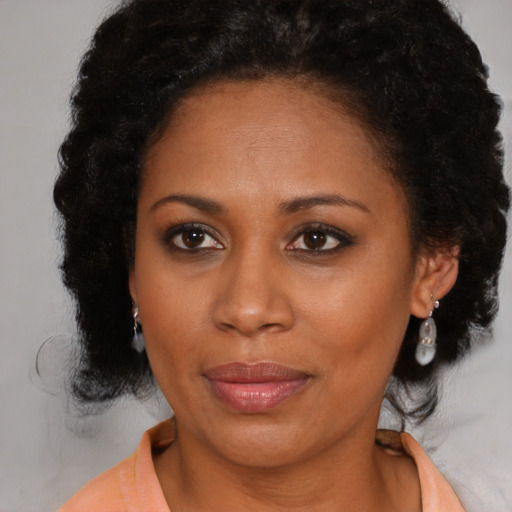 Joyful black young-adult female with medium  brown hair and brown eyes