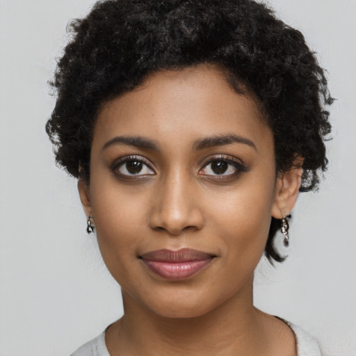 Joyful black young-adult female with short  black hair and brown eyes