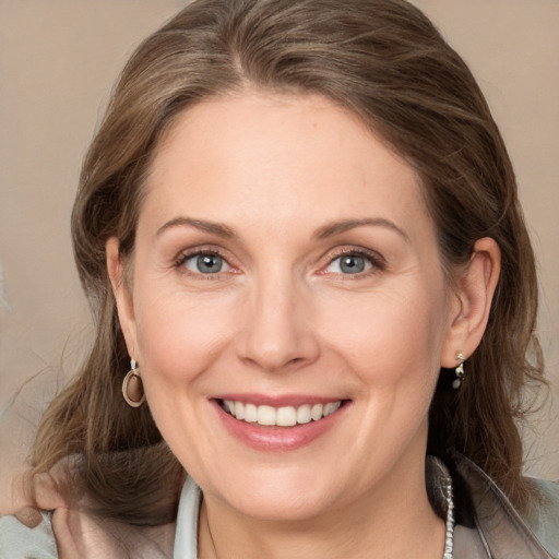 Joyful white adult female with medium  brown hair and grey eyes