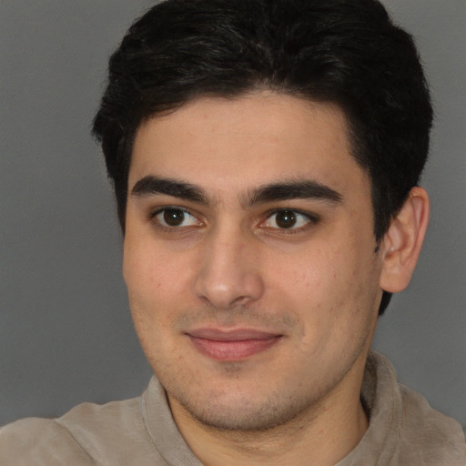 Joyful latino young-adult male with short  brown hair and brown eyes