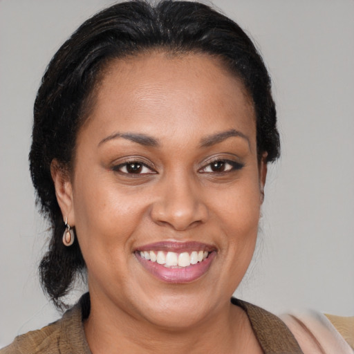 Joyful latino adult female with medium  brown hair and brown eyes