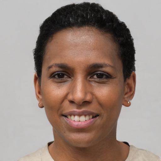 Joyful black young-adult female with short  black hair and brown eyes