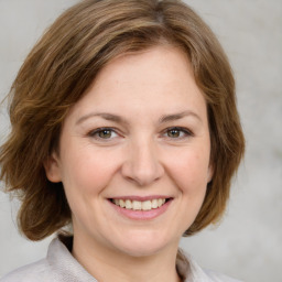 Joyful white young-adult female with medium  brown hair and green eyes