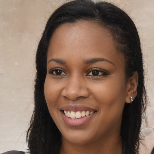 Joyful black young-adult female with long  black hair and brown eyes