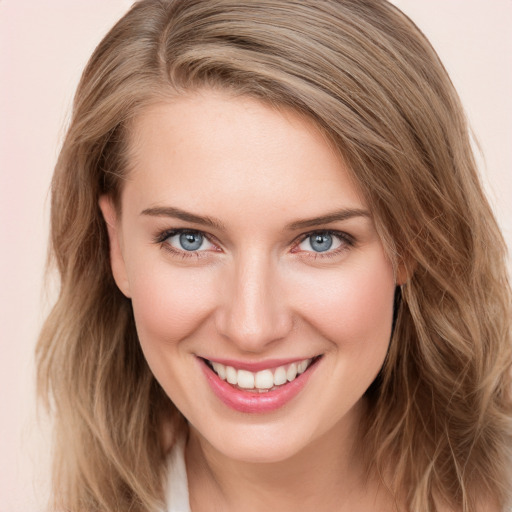 Joyful white young-adult female with long  brown hair and blue eyes