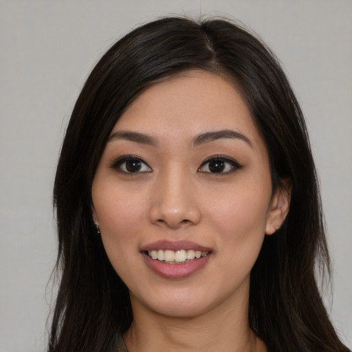 Joyful latino young-adult female with long  brown hair and brown eyes