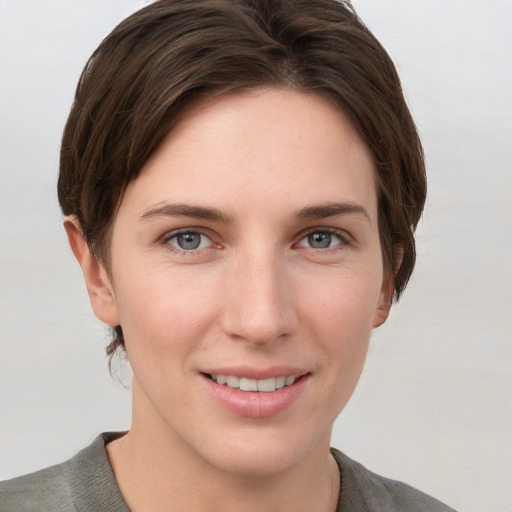 Joyful white young-adult female with short  brown hair and grey eyes