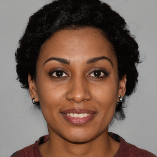 Joyful black young-adult female with short  brown hair and brown eyes