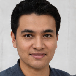 Joyful latino young-adult male with short  brown hair and brown eyes