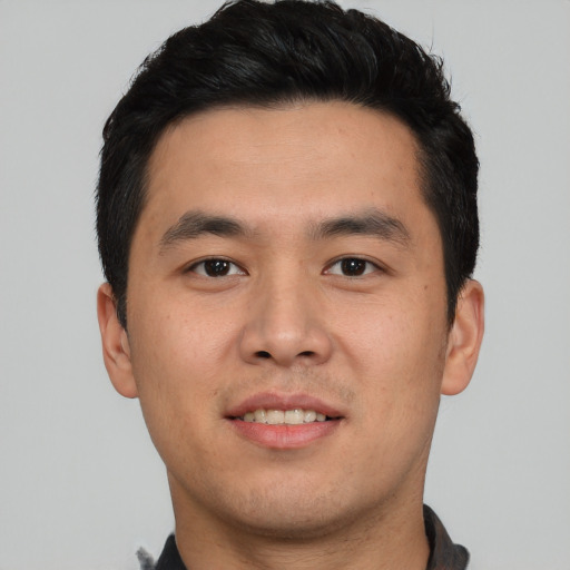 Joyful asian young-adult male with short  black hair and brown eyes