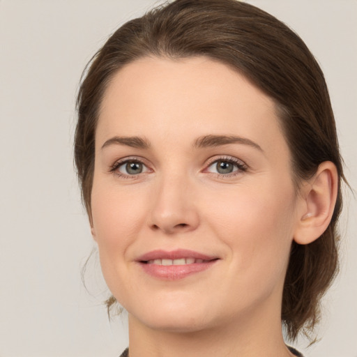 Joyful white young-adult female with medium  brown hair and grey eyes