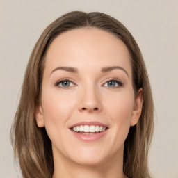 Joyful white young-adult female with long  brown hair and green eyes