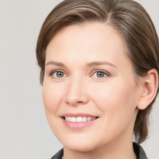 Joyful white young-adult female with medium  brown hair and grey eyes