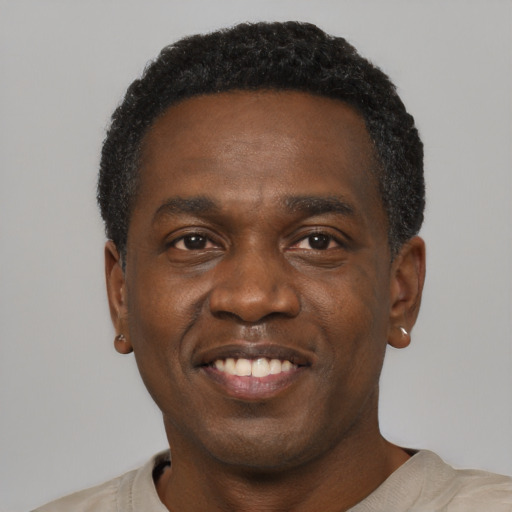 Joyful black young-adult male with short  black hair and brown eyes