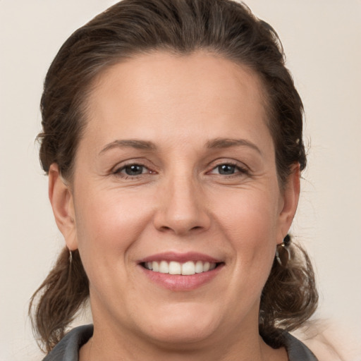 Joyful white adult female with medium  brown hair and brown eyes