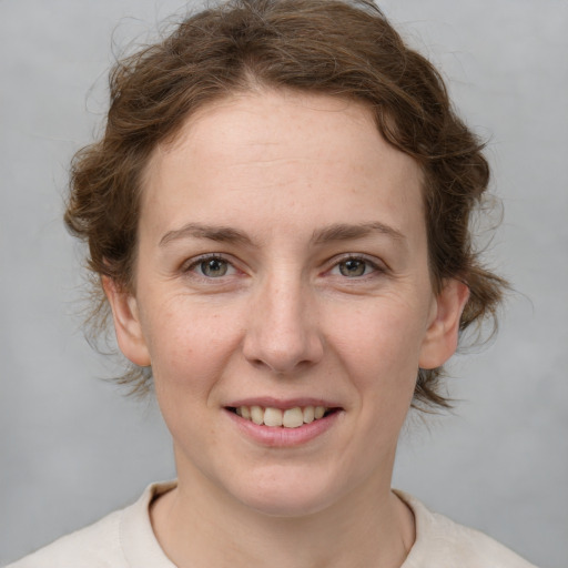 Joyful white young-adult female with short  brown hair and grey eyes