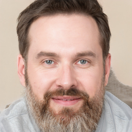 Joyful white adult male with short  brown hair and grey eyes