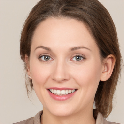 Joyful white young-adult female with medium  brown hair and grey eyes