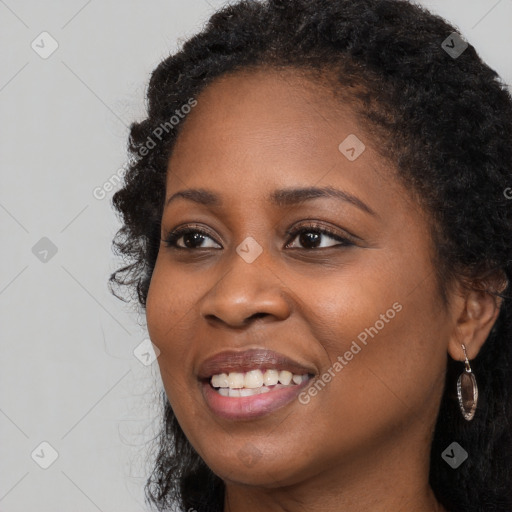 Joyful black young-adult female with long  brown hair and brown eyes