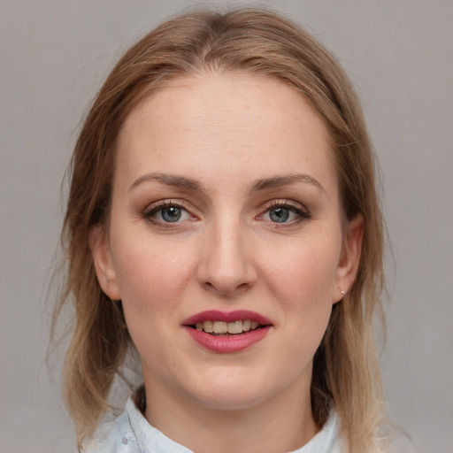 Joyful white young-adult female with medium  brown hair and blue eyes