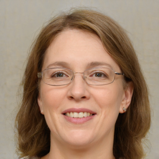 Joyful white adult female with medium  brown hair and blue eyes