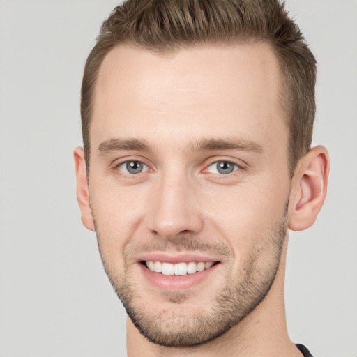 Joyful white young-adult male with short  brown hair and grey eyes