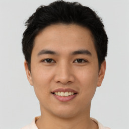 Joyful asian young-adult male with short  brown hair and brown eyes