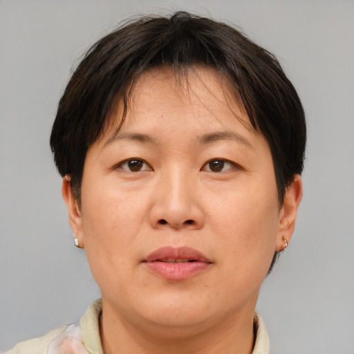 Joyful asian adult female with short  brown hair and brown eyes