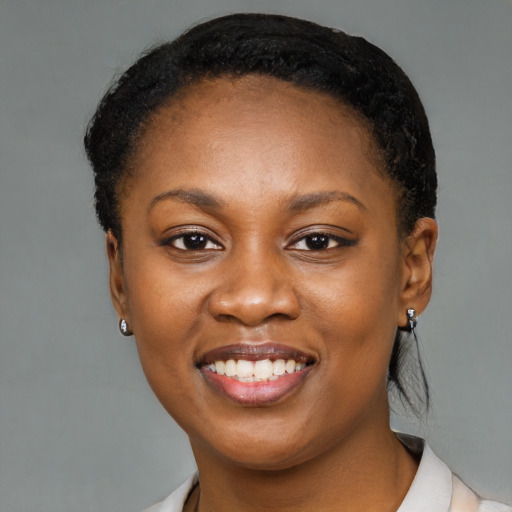 Joyful black young-adult female with short  black hair and brown eyes