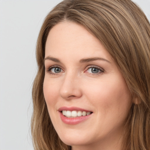 Joyful white young-adult female with long  brown hair and grey eyes