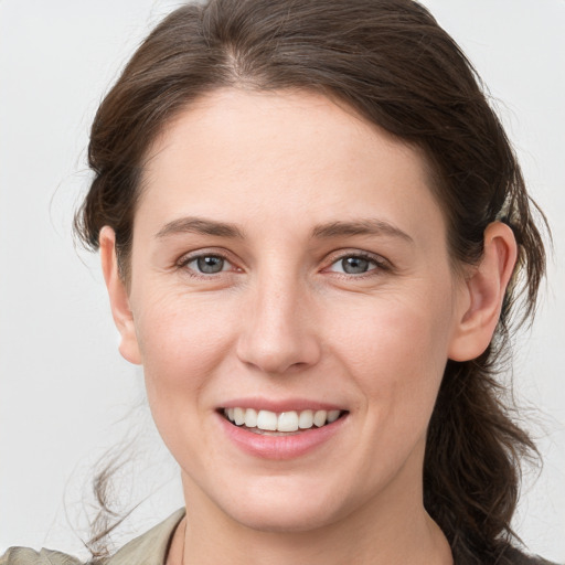 Joyful white young-adult female with medium  brown hair and grey eyes