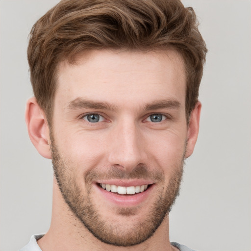 Joyful white young-adult male with short  brown hair and grey eyes