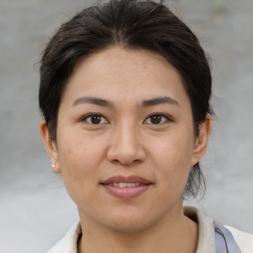 Joyful asian adult female with medium  brown hair and brown eyes