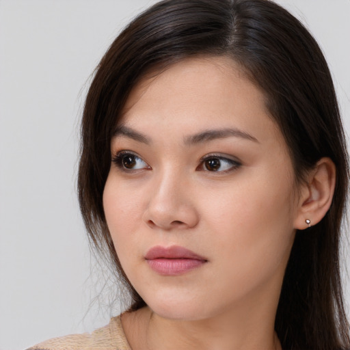 Joyful asian young-adult female with long  brown hair and brown eyes