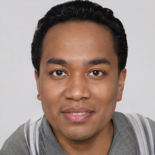 Joyful black young-adult male with short  black hair and brown eyes